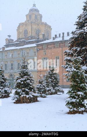 Weihnachtsbäume mit Schnee vor der Kirchenkuppel San Lorenzo im Stadtzentrum von Turin. Piazza Castello, Turin, Italien. Stockfoto