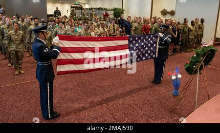 Mitglieder der Base Honor Guard haben im Rahmen einer Gedenkfeier am Yokota Air Base, Japan, am 27. Mai 2022 eine US-Flagge gefaltet. Das Fahnenfalten ist Teil der Beerdigungen des US-Militärs und wird auch während der Feierlichkeiten zum Memorial Day durchgeführt, um gefallenen Mitgliedern der Streitkräfte Respekt zu zollen. Die Mitglieder der Ehrenwache falten die Flagge 13 Mal in einem Dreiecksmuster, um die ursprünglichen 13 US-Kolonien darzustellen. Nach Abschluss des Vorgangs werden nur blaue und weiße Sterne angezeigt. Stockfoto