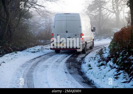 Weißer Lieferwagen fährt im Winter auf Eis und gefrorenem Schnee auf einer vereisten Landstraße. Januar 2023 Carmarthenshire Wales UK Großbritannien KATHY DEWITT Stockfoto