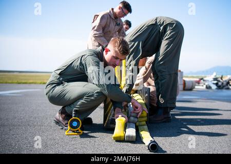 USA Marine Corps Lance CPL. Zachary Blake, ein Expeditionär-Feuerwehrmann/Rettungsexperte mit Hauptquartier und Hauptquartier-Staffel, Marine Corps Air Station (MCAS) Iwakuni, packt einen Feuerwehrschlauch während einer Feuerwehrübung auf MCAS Iwakuni, Japan, 27. Mai 2022. Marines führen diese Feuerschulung monatlich durch, um die Bereitschaft im Falle eines Flugzeugnotfalls sicherzustellen. Stockfoto