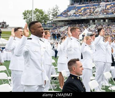 ANNAPOLIS, Md (27. Mai 2022) USA Marineakademie-Klasse von 2022 Seeschifffahrtsleuten steht auf und leistet den Amtseid, während ihrer Abschlussfeier und Kommissionierungszeremonie im Navy-Marine Corps Memorial Stadium Fähnrich der Navy zu werden. Die Klasse der 2022 schloss 1.100 Fähnrich ab und wurde von Präsident Joseph R. Biden Jr. Stockfoto