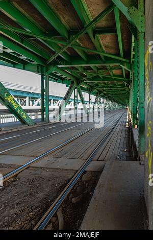 Warschau, Polen - März 2022: Lange Gdanski-Brücke aus Holz und Metall mit Straßenbahnschienen und grünem Dach Stockfoto