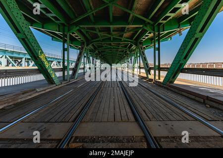 Warschau, Polen - März 2022: Lange Gdanski-Brücke aus Holz und Metall mit Straßenbahnschienen und grünem Dach Stockfoto