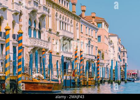 Großer Kanal in Venedig, Italien, mit hölzernen Gondelpfosten vor alten Häusern Stockfoto