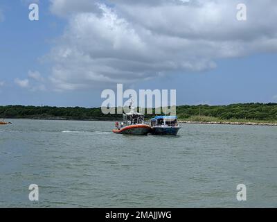 Eine Küstenwache Galveston 45-Fuß Response Boat – mittlere Crew zieht auch die Baywatch, ein Delfin Sightseeing Schiff, das seine Steuerung in der Nähe des Seawolf Park in Galveston, Texas, verloren hat, am 28. Mai 2022. Die Besatzung der Küstenwache schleppte das Schiff und seine 33 Passagiere und Besatzung sicher zum Pier 21 in Galveston. Stockfoto