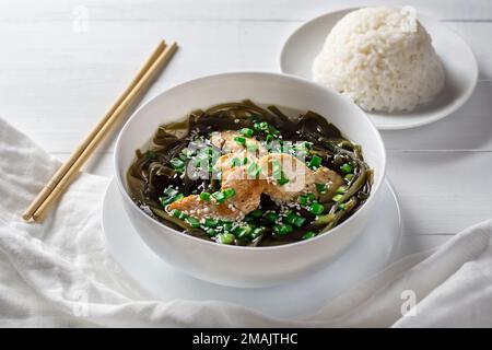 Koreanische Algensuppe mit Fleisch in einer weißen Schüssel und gekochtem Reis. Geburtstagssuppe. Traditionelle koreanische Küche. Gesunde Ernährung. Schwangerschaft. Benutzerdefiniert. Stockfoto