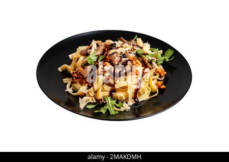 Bolognesische Pasta mit Pilzen und mit Rucola gegossener Balsamsauce auf isoliertem Hintergrund Stockfoto