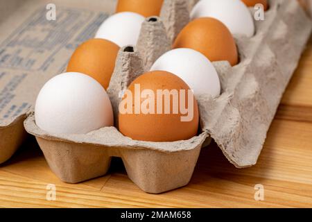 Frische braune und weiße Hühnereier im Karton. Ökologisches, Käfigfreies und Geflügelzuchtkonzept. Stockfoto