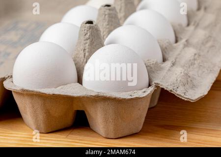 Frische weiße Hühnereier im Karton. Ökologisches, Käfigfreies und Geflügelzuchtkonzept. Stockfoto