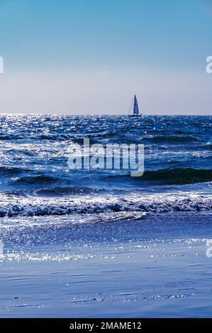 Segelboot am Horizont, zwischen dem Ozean und dem Himmel Stockfoto