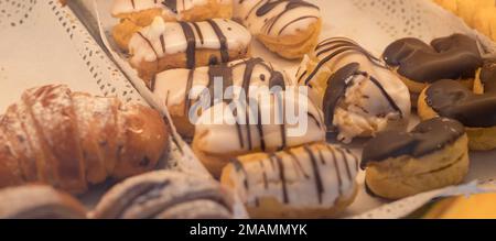 Schokoladencroissants und anderes Gebäck auf der Theke in der Konditorei. Frisches Gebäck. Süße Desserts. Verkauf von Süßwaren. Stockfoto