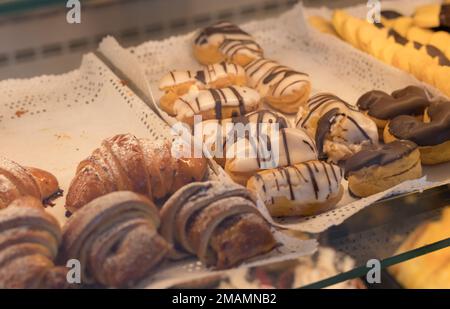 Schokoladencroissants und anderes Gebäck auf der Theke in der Konditorei. Frisches Gebäck. Süße Desserts. Verkauf von Süßwaren. Stockfoto