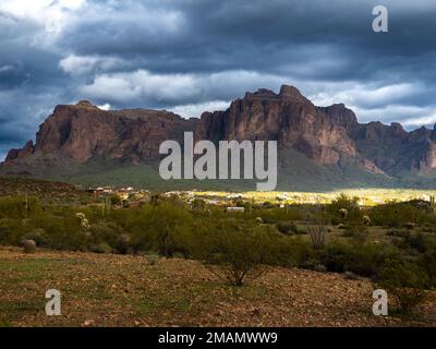 Während sich eine Wetterfront durch den Bundesstaat Arizona bewegt, bilden Wolken kontrastierende Elemente über der Superstition Mountain Range östlich von Phoenix Stockfoto