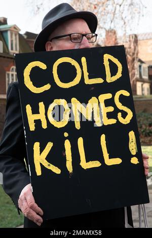 London, Großbritannien. 19. Januar 2023. Ein Aktivister von Fuel Poverty Action hält ein Schild mit der Aufschrift "Cold Homes Kill" auf einer Mahnwache vor dem Parlament, um die Menschen zu betrauern, die letztes Jahr durch die Treibstoffarmut getötet wurden. Nach Angaben des Amtes für nationale Statistik (ONS) gab es im letzten Jahr 13.400 übermäßige Wintertote, von denen etwa ein Drittel auf Kälte- und feuchte Häuser zurückzuführen war. Nach der Nachtwache marschierten die Palmträger langsam in die Downing Street mit einem Sarg mit der neuesten Zahl an Todesopfern, um Premierminister Rishi Sunak einen Brief zu überbringen, in dem sie zu sofortigen Maßnahmen zur Beendigung der Treibstoffarmut aufforderten. Kredit: Mark Kerrison/ Stockfoto