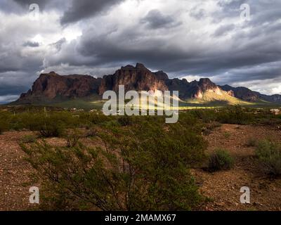 Während sich eine Wetterfront durch den Bundesstaat Arizona bewegt, bilden Wolken kontrastierende Elemente über der Superstition Mountain Range östlich von Phoenix Stockfoto