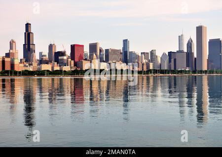 Chicago, Illinois, USA. Der Lake Michigan und die Gebäude der Skyline von Chicago spiegeln sich am späten Frühling wieder. Stockfoto