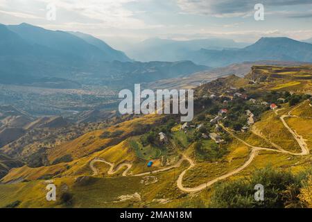 Gewundene Straße in den Dagestan Mountains mit großer Bergformation im Hintergrund Stockfoto