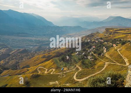 Gewundene Straße in den Dagestan Mountains mit großer Bergformation im Hintergrund Stockfoto