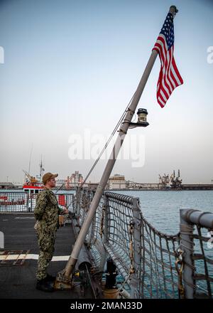 JEDDAH, Saudi-Arabien (31. Mai 2022) Aviation Technician 2. Class Tyler thompson erhebt den nationalen Fähnrich an Bord des Kampfschiffs USS Sioux City (LCS 11), während er am 31. Mai in Jeddah, Saudi-Arabien, am Pier sitzt. Sioux City wird im US-5.-Flottengebiet eingesetzt, um die Sicherheit und Stabilität des Seeverkehrs im Nahen Osten zu gewährleisten. Stockfoto