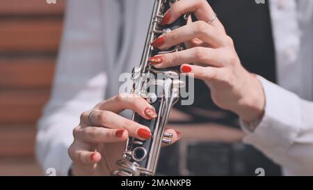 Im Sommer spielt ein Mädchen Klarinette im Park. Stockfoto