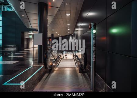 Ein zeitgenössischer Flughafen in Zürich, das Gebiet mit einem selektiven Fokus auf beweglichen Laufstegen, die zu einem unteren Stockwerk mit einem grünen Licht in f führen Stockfoto