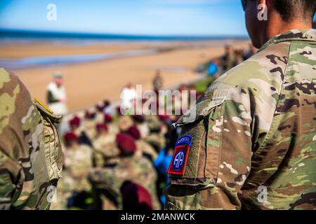 Mitglieder des Dienstes hören Keith Nightingale, wie sie über den D-Day sprechen, während sie über Omaha Beach blicken, während der Woche des D-Day am 1. Juni 2022. Als Teil des 78. Jahrestags des D-Day. Nightingale unterrichtet Soldaten seit mehr als 40 Jahren über die Bedeutung des D-Day aus strategischer und operativer Sicht. Stockfoto