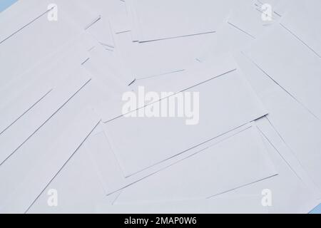 Mehrere weiße Papierstücke auf blauem Hintergrund mit Kopierbereich in der oberen rechten Ecke und in der unteren linken Ecke Stockfoto