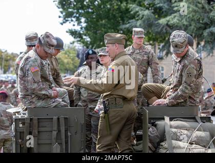 USA Armeesoldaten, die der 4. Infanterie-Division zugeteilt sind, werden nach der 2. Gedenkfeier der Panzerdivision am 2. Juni 2022 in der Mairie de Carentan-les-Marais in Carentan, Frankreich, auf dem M3. Panzertransport von einem engagierten Historiker der 2. Panzerdivision gezeigt. Die 4. Inf. Div wurde am 26. Januar 1944 nach England geschickt, um sich auf die Invasion vorzubereiten, die die Division aufforderte, Utah Beach anzugreifen. Stockfoto