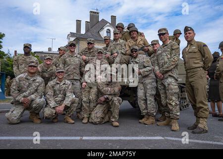 USA Soldaten des 1. Bataillons, des 8. Infanterie-Regiments, des 3. Bewaffneten Brigaden-Kampfteams, der 4. Infanterie-Division. Pose für ein Foto mit einem M3. Gepanzerten halbspurigen Personentransporter, der die Nummer von 1-8 und historisch engagierten Freiwilligen hat, die die 2. Panzerdivision repräsentieren, 2. Juni 2022, Während der Gedenktafel der Panzerdivision 2. in Mairie de Carentan-les-Marais, Carentan, Frankreich. Am D-Day vollbrachten die Alliierten den Tiefenschlag und die Luftunterstützung, die das Ende des Zweiten Weltkriegs bewirkten Am Ende die Stärke der Allianz, engagierte Entschlossenheit und Stockfoto