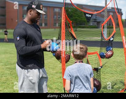 Cincinnati Bengals Defensive End Jeff Gunter unterzeichnet einen Fußball für eine Wright-Patterson Air Force Base, Ohio, ein Militärkind in der von der USO gesponserten Cincinnati Bengals Football Skills Clinic, 3. Juni 2022. Eine Gruppe von bengalischen Anfängern hatte ein Mittagessen mit Airmen, tourte durch die Basis und leitete die Skills Clinic für 99 Wright-Patt-Militärkinder. 88 ABW, BENGALS, NFL, USAF, WPAFB, Stockfoto