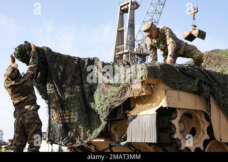 Ein marokkanischer Soldat hilft einem US-Soldaten dabei, ein M1A3 Abrams-Panzer mit Camo-Netzen zu verbergen, bevor er den Hafen von Agadir während der Übung zum Afrikanischen Löwen 22, 4. Juni 2022, Agadir, Marokko, verlässt. Die US-Panzer wurden sowohl mit US-amerikanischen als auch marokkanischen Transportfahrzeugen vom Hafen zu ihrem Aufenthaltsort in Tifnit, Marokko, transportiert. Der afrikanische Löwe 2022 ist in den USA Die größte gemeinsame jährliche Übung des Kommandos Afrika, die von Marokko, Ghana, Senegal und Tunesien veranstaltet wird, vom 6. Bis 30. Juni. Mehr als 7.500 Teilnehmer aus 28 Ländern und der NATO trainieren zusammen mit dem Schwerpunkt auf der Verbesserung der Bereitschaft für die USA Stockfoto