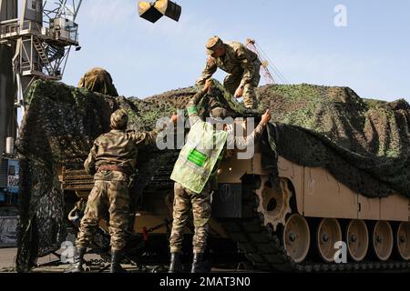 Marokkanische Soldaten helfen einem US-Soldaten dabei, ein M1A3 Abrams-Panzer mit Camo-Netzen zu verbergen, bevor sie den Hafen von Agadir während der Übung zum Afrikanischen Löwen 22, 4. Juni 2022, Agadir, Marokko, verlassen. Die US-Panzer wurden sowohl mit US-amerikanischen als auch marokkanischen Transportfahrzeugen vom Hafen zu ihrem Aufenthaltsort in Tifnit, Marokko, transportiert. Der afrikanische Löwe 2022 ist in den USA Die größte gemeinsame jährliche Übung des Kommandos Afrika, die von Marokko, Ghana, Senegal und Tunesien veranstaltet wird, vom 6. Bis 30. Juni. Mehr als 7.500 Teilnehmer aus 28 Ländern und der NATO trainieren zusammen mit dem Schwerpunkt auf der Verbesserung der Bereitschaft für die U Stockfoto