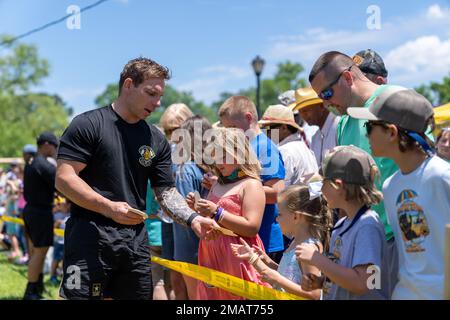 Staff Sgt. Logan Maples vom Golden Knights Black Demonstrationsteam gibt jungen Fans beim Bärenfestival in Plymouth, NC, am 4. Juni 2022 Sticker. Stockfoto