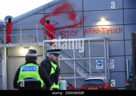 Edinburgh, Großbritannien. 19. Januar 2023. Während der Demonstration sprüht ein palästinensischer Aktionist vor dem Gebäude Malbotschaften aus. Palästinensische Aktivisten durchtrennten den Sicherheitszaun mitten in der Nacht und stiegen auf das Dach der Waffenfabrik Leonardo in Edinburgh. Sie protestieren und unterstreichen die Tatsache, dass Leonardo Laserleitsysteme für israelische F35 Kampfflugzeuge und Hermes 450 Drohnen bereitstellt. Diese Munition wird gegen das palästinensische Volk in Gaza und anderswo eingesetzt. (Foto: Martin Pope/SOPA Images/Sipa USA) Guthaben: SIPA USA/Alamy Live News Stockfoto