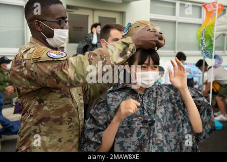 USA Air Force Tech. Sgt. Henson Greene, Left, interagiert mit einem Mitglied der japanischen Öffentlichkeit während der Hofu Air Show 2022 am Hofu-Kita Air Base, Japan, 5. Juni 2022. Die Luftwaffe der 459. Und der 374. Einsatzstaffel nahmen am Hofu Air Festival Teil, um bilaterale Beziehungen zu ihren japanischen Kollegen und der größeren Hofu-Gemeinde zu fördern. Stockfoto