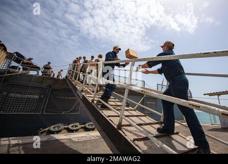 HAFEN VON DSCHIBUTI (6. JUNI 2022) - USA Marinesoldaten des Kampfschiffs USS Sioux City (LCS 11) erhalten vom CAPM Lemonnier im Hafen von Dschibuti am 6. Juni 2022 Hilfsgüter. Sioux City wird im US-5.-Flottengebiet eingesetzt, um die Sicherheit und Stabilität des Seeverkehrs im Nahen Osten zu gewährleisten. Stockfoto