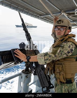 HAFEN VON DSCHIBUTI (5. JUNI 2022) - USA Navy Boatswains Mate 3. Klasse Wang, Peng steht Wache an Bord der Maritime Expeditionary Security Squadron One (MSRON-1) 34-ft Patrouillenboot und bietet gleichzeitig Sicherheit für das kleine Kampfschiff USS Sioux City (LCS 11) während seines Aufenthalts im Hafen von Dschibuti, 5. Juni 2022. Stockfoto