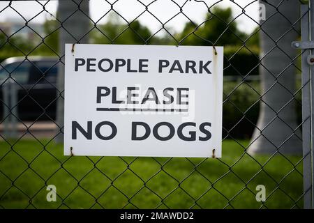 Ein Schild auf einem Zaun zu einem Park in Amerika mit der Aufschrift People Park Please no Dogs (People Park Bitte keine Hunde) Stockfoto