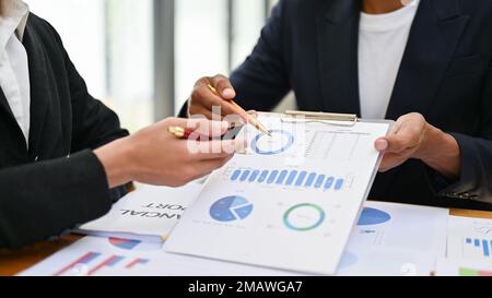 Professioneller asiatischer Geschäftsmann oder männlicher Finanzberater, der seinem Geschäftskunden ein Diagramm der Umschlagshäufigkeit der Investitionen erläutert und einen Finanzmeeti hat Stockfoto