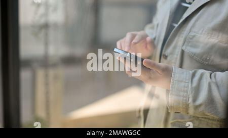 Cropped Shot, Eine Hipster-Frau, die ihr Handy benutzt, mit ihren Freunden chattet, eine mobile App verwendet. Stockfoto