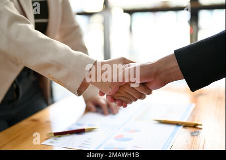 Professioneller Geschäftsmann, der sich mit seinem Geschäftspartner während des Meetings die Hand schüttelt. Geschäftsverhandlungskonzept. Zugeschnittenes und Nahaufnahme der Hand Stockfoto