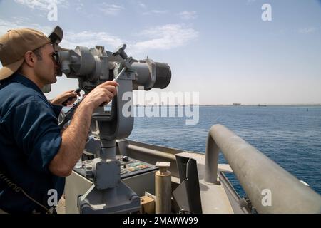 DSCHIBUTI (6. Juni 2022) LT. Commander. Moises Gonzalez blickt durch das Fernglas während einer Evolution von Meer und Anker an Bord des Kampfschiffs USS Sioux City (LCS 11), Juni 6. Sioux City wird im US-5.-Flottengebiet eingesetzt, um die Sicherheit und Stabilität des Seeverkehrs im Nahen Osten zu gewährleisten. Stockfoto