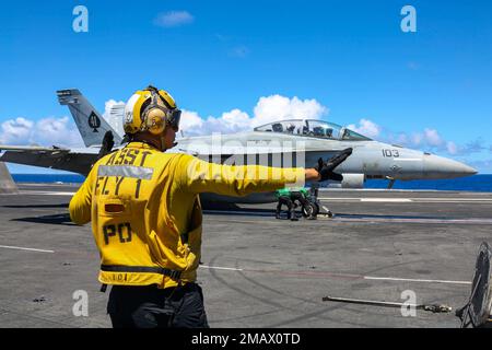 PHILIPPINE SEA (6. Juni 2022) Aviation Boatswain’s Mate (Handling) 3. Class Luis Placencia aus Oakland, Kalifornien, leitet ein F/A-18F Super Hornet, das dem „Black Aces“ der Streikkkampfgeschwader (VFA) 41 auf dem Cockpit des Flugzeugträgers der Nimitz-Klasse USS Abraham Lincoln (CVN 72) zugewiesen ist. Die Abraham Lincoln Strike Group befindet sich in einem geplanten Einsatz im US-7.-Flottenbereich, um die Interoperabilität durch Allianzen und Partnerschaften zu verbessern und gleichzeitig als einsatzbereite Truppe zur Unterstützung einer freien und offenen Region Indo-Pacific zu fungieren. Stockfoto