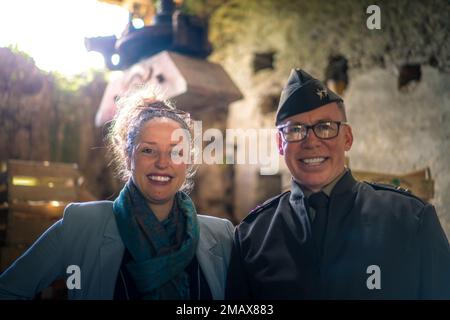 Mrs. Florie Tap, die Urenkelin von Madame Brisset und Major General Greg Brady, kommandierender General des 10. Army Air and Missile Defense Command, stehen in der Scheune, in der Madame Brisset am 6. Juni 1944 drei amerikanische Fallschirmjäger vor feindlichen Patrouillen versteckte. Stockfoto