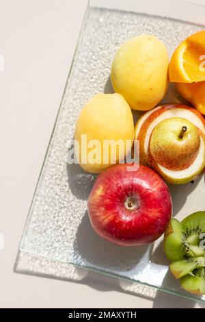 Frisches Obst auf dem weißen Tisch. Akzeptable Früchte für Diabetes. Kiwis, Weintrauben, Orange, Äpfel, Birnen, gesunde Ernährung und kalorienarme Ernährung Stockfoto