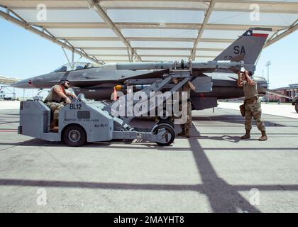 Staff Sgt. Dyshay Smagacz, Staff Sgt. Hector Rodgriguez Jr. und Tech Sgt. Joseph Ramos, 149. Fighter Wing Aircraft Armament Systems Technicians, arbeiten am Transport einer Trainingskanone von einer F-16 zu einer anderen auf der Joint Base San Antonio-Lackland, Texas, 7. Juni 2022. Die Bewaffnungstechniker der Flugzeuge sind für die Wartung der Waffensysteme des Flugzeugs und die Konfiguration der Ladungen für jeden Flug verantwortlich. (Air National Guard Foto von Staff Sergeant Ryan Mancuso) Stockfoto