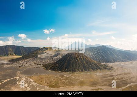 Blick von oben, atemberaubender Panoramablick auf den Mt Batok, Mt Bromo und Mt Semeru in der Ferne an einem sonnigen Tag. Stockfoto