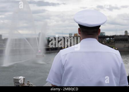 LT. Michael Tisdall, Ausbildungsoffizier des Zerstörers der Zumwalt-Klasse USS Michael Monsoor (DDG 1001), beobachtet, wie ein Feuerboot Wasser spritzt, während das Schiff in Portland, Oregon, ankommt, für Portland Fleet Week 2022, Juni 9. Die Portland Fleet Week ist eine feierliche Feier der Seeverkehrsdienste und bietet den Einwohnern Oregons die Gelegenheit, Matrosen, Marines und Küstenwachmänner zu treffen und die neuesten Möglichkeiten der heutigen Seeverkehrsdienste aus erster Hand zu erleben Stockfoto