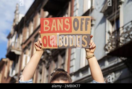 Eine Frau mit einem Schild mit dem Slogan Bans Off our Bodies. Protestträger mit Plakat zur Unterstützung des Abtreibungsrechts bei der Protestkundgebung. Stockfoto