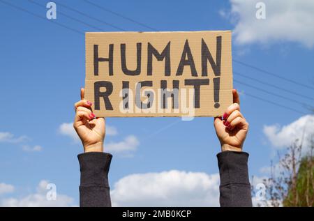 Weibliche Hände, die während der Manifestation ein Schild mit der "Human Right"-Plakette halten. Frau mit Banner, die Abtreibungsrechte bei Protestkundgebungen unterstützt. Stockfoto